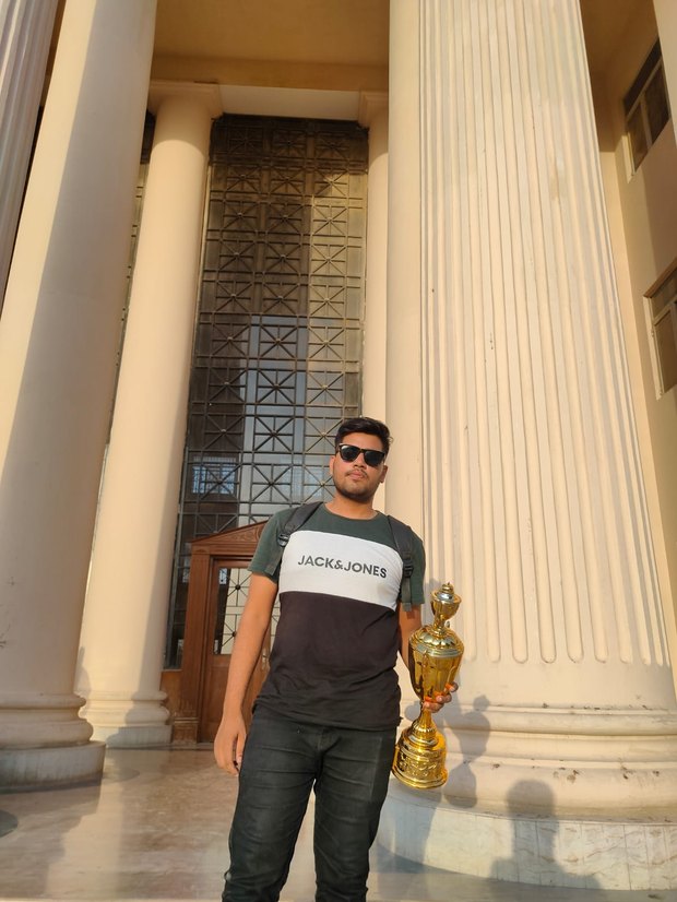Coach holding the trophy won at the Sindh Games 2024 chess event